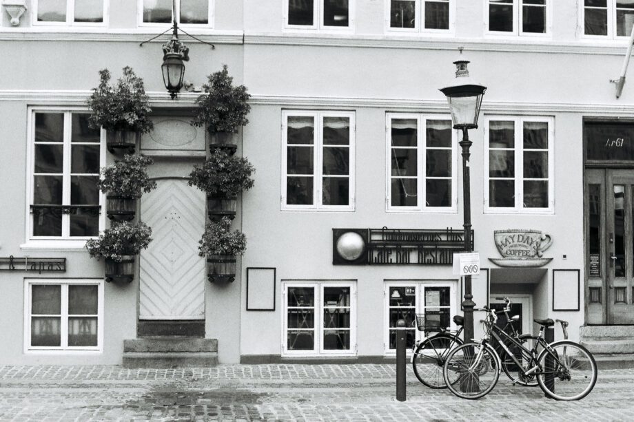 een zwart-witfoto van twee fietsen die voor een gebouw geparkeerd staan.